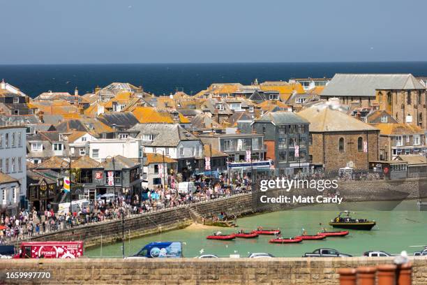 Boots moored in the harbour float on the high tide at St Ives on May 30, 2023 in Cornwall, England. St Ives has struggled for many years with...