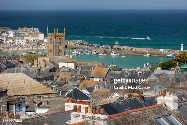 Boots moored in the harbour float on the high tide at St Ives on May 30, 2023 in Cornwall, England. St Ives has struggled for many years with...