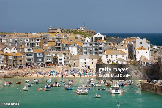 Boots moored in the harbour float on the high tide at St Ives on May 30, 2023 in Cornwall, England. St Ives has struggled for many years with...