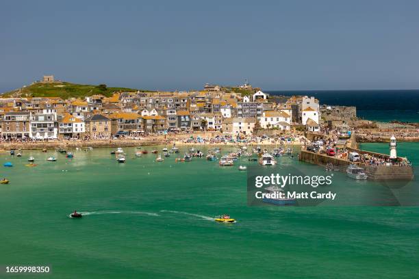 Boots moored in the harbour float on the high tide at St Ives on May 30, 2023 in Cornwall, England. St Ives has struggled for many years with...