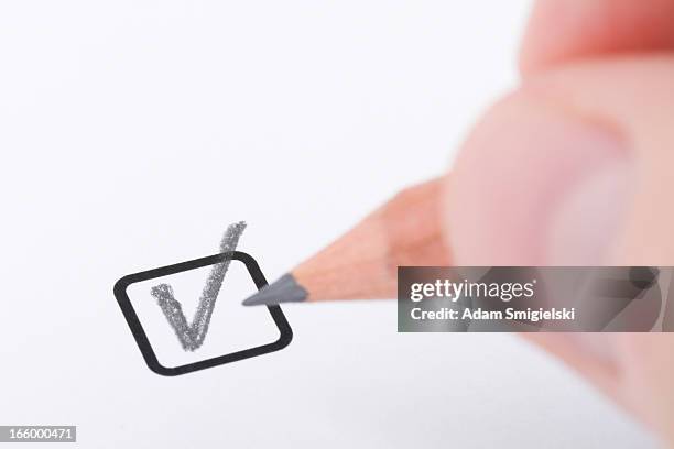 hand with pencil writing "check mark" - pencil on white paper stock pictures, royalty-free photos & images