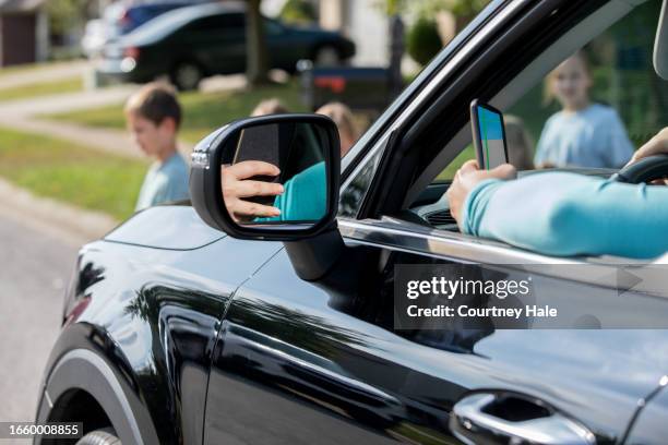 distracted driver is texting and doing her makeup, almost hitting children in the crosswalk - distracted driver stock pictures, royalty-free photos & images