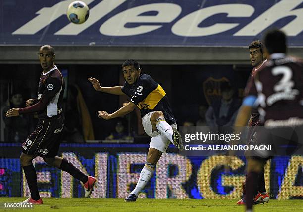 Boca Juniors' midfielder Juan Roman Riquelme kicks the ball next to Lanus' midfielder Guido Pizarro during their Argentine First Division football...