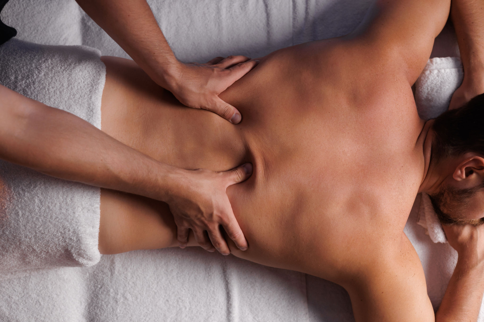 Handsome man having restorative back massage in spa salon, enjoying relaxing atmosphere, recharging after work. Masseuse gives therapeutic back massage to a visitor, the concept of healthy lifestyle. Handsome man having restorative back massage in spa salon, enjoying relaxing atmosphere, recharging after work. Masseuse gives therapeutic back massage to a visitor, the concept of healthy lifestyle.