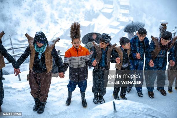 Kurdistan, Iran. Men and women are seen dancing amidst the snow in the village of Oraman Takht, celebrating the Pir-e-Shalyar ceremony.