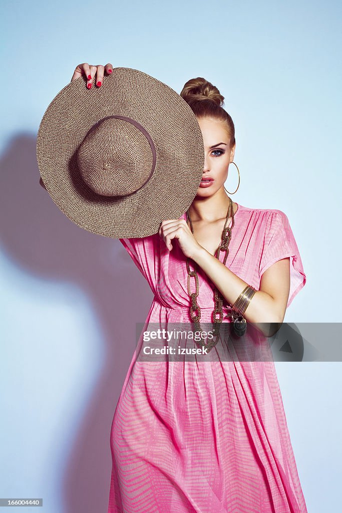 Glamour portrait of woman posing with sun hat