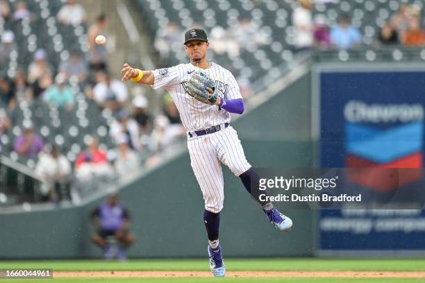 Ezequiel Tovar of the Colorado Rockies throws to first base after fielding a ground ball against the Toronto Blue Jays in the eighth inning at Coors...