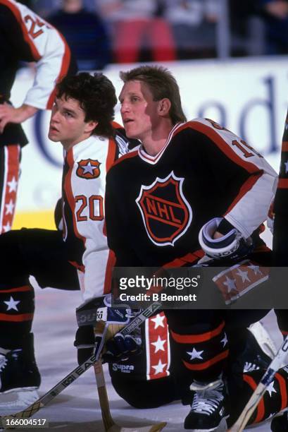 Brett Hull of the Campbell Conference and the St. Louis Blues kneels next to Luc Robitaille of the Los Angeles Kings before the 1990 41st NHL...