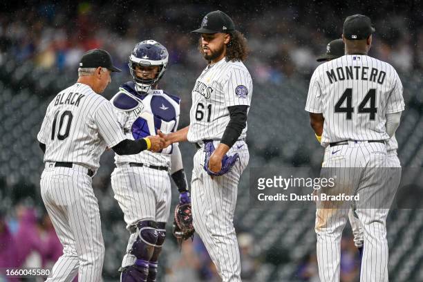 Bud Black of the Colorado Rockies takes the ball from Justin Lawrence of the Colorado Rockies after a ninth inning pitching change against the...