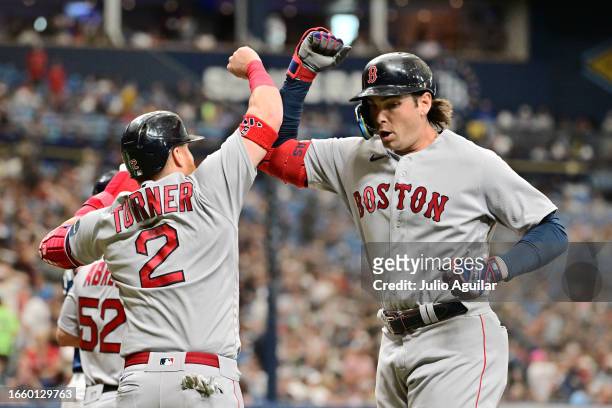 Triston Casas celebrates with Justin Turner of the Boston Red Sox after hitting a three-run home run in the sixth inning against the Tampa Bay Rays...