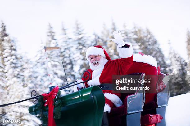 cheerful santa claus waving from sleigh in snow, copy space - christmas driving stockfoto's en -beelden