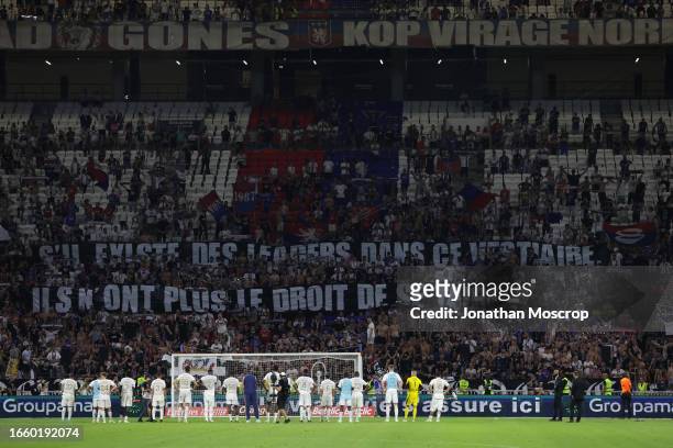 Olympique Lyonnais players look on as the fans display banners bearing the message; "If There are any leaders in this dressing room they no longer...