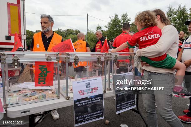 Young Moroccan football fan makes a donation for the victims of the earthquake in Morocco at a collection point on the sidelines of the international...