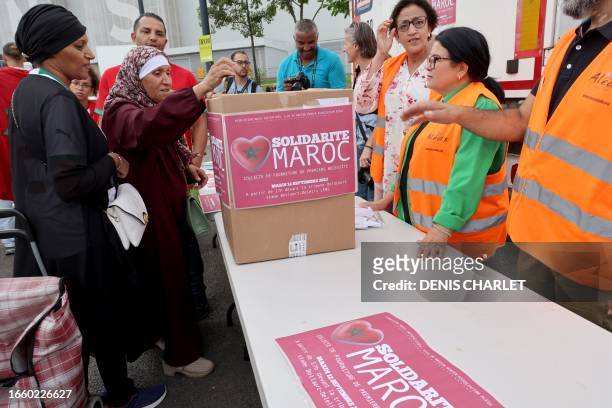 Woman makes a donation for the victims of the earthquake in Morocco at a collection point on the sidelines of the international friendly football...