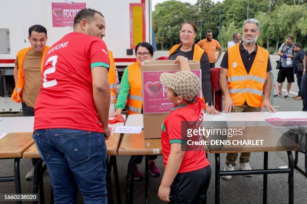 Young Moroccan football fan makes a donation for the victims of the earthquake in Morocco at a collection point on the sidelines of the international...