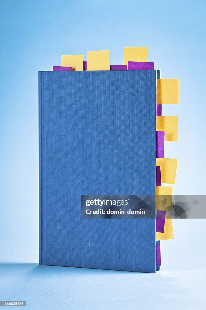 Blue notepad with yellow and purple sticky post-it notes