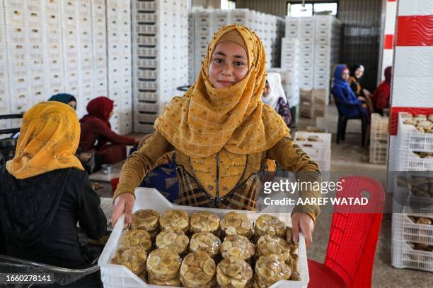 Woman holds a batch of packaged dried figs being transported for sale from a processing facility in the village of Kurin in the rebel-held southern...
