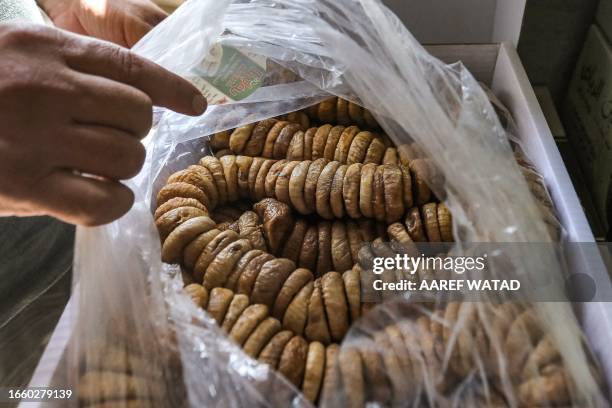 Man packages a batch of stringed dried figs at a processing facility in the village of Kurin in the rebel-held southern part of Syria's northwestern...