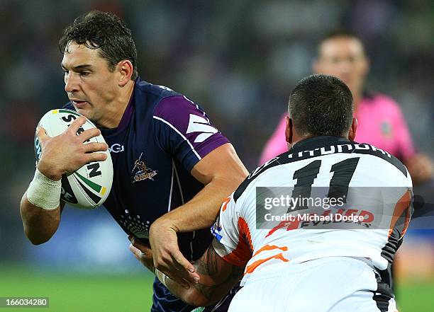 Bodene Thompson of the Tigers tackles Billy Slater of the Storm during the round 5 NRL match between the Melbourne Storm and the Wests Tigers at AAMI...