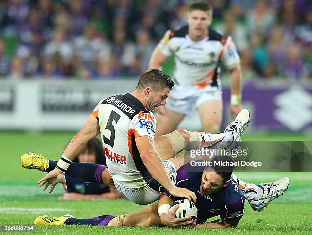 Billy Slater of the Storm contests for the ball against James Tedesco of the Tigers during the round 5 NRL match between the Melbourne Storm and the...