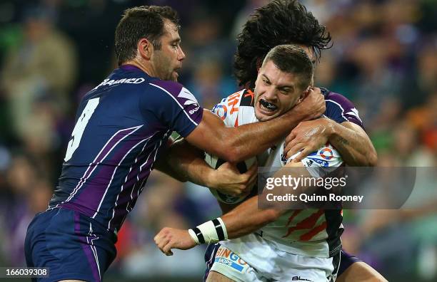 James Tedesco of the Tigers is tackled by Cameron Smith of the Storm during the round 5 NRL match between the Melbourne Storm and the Wests Tigers at...