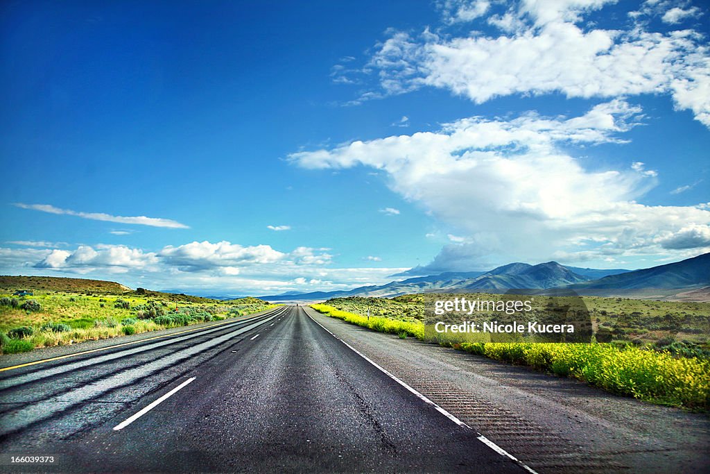 Empty mountain road on sunny summer blue sky day