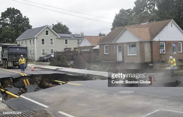 Leominster, MA Crews work after a torrent of water washed out the intersection of Pleasant and Colburn Streets, leaving a house there an island on...