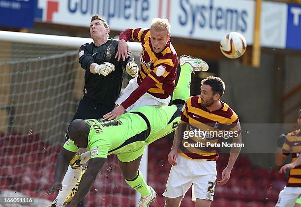 Jon McLaughlin of Bradford City punches the ball clear from team mates Andrew Davies and Rory McArdle and Adebayo Akinfenwa of Northampton Town...