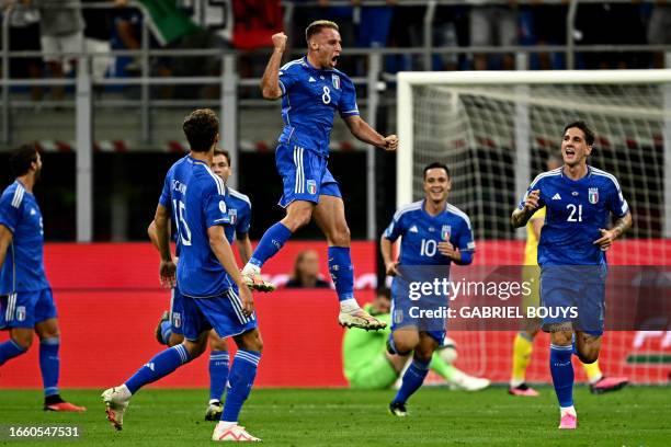 Italy's midfielder Davide Frattesi jumps in the air in celebration after scoring Italy's first goal during the Euro 2024 football tournament Group C...