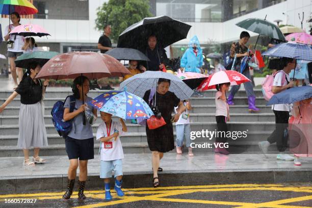 Students are picked up by their family members after school in a rain on September 4, 2023 in Xiamen, Fujian Province of China. Typhoon Haikui will...