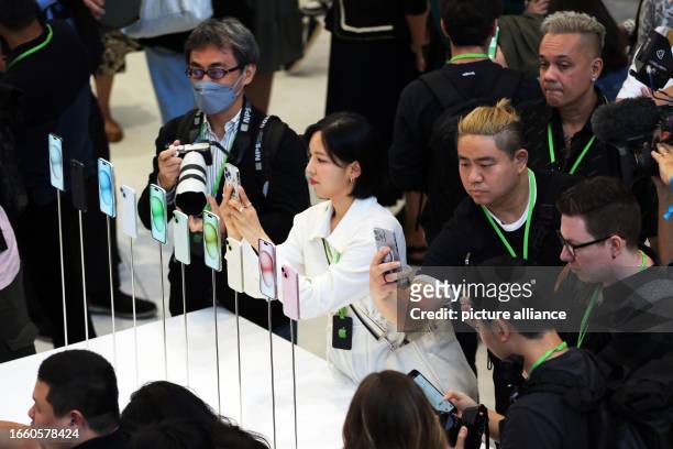 September 2023, USA, Cupertino: Journalists and visitors take pictures of the new iPhone 15 after the presentation at the launch of the new iPhone...