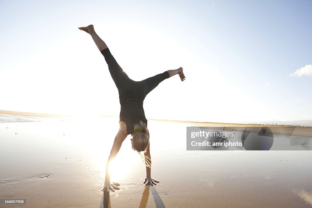 Woman doing a cartwheel on the beach