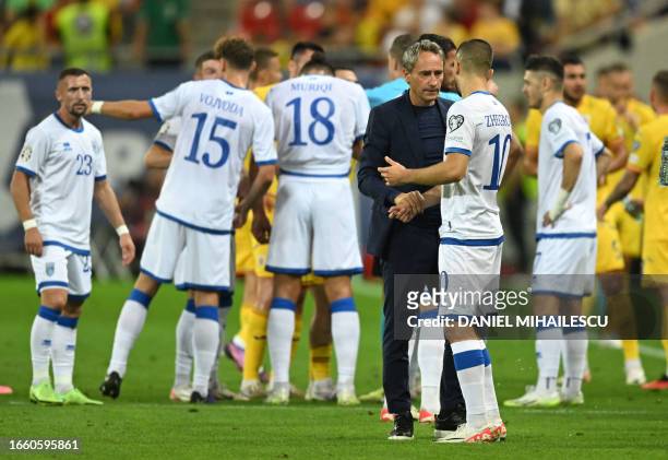 Kosovo's Slovenian coach Primoz Gliha and Kosovo's midfielder Edon Zhegrova react as the game was stopped due to a banner displayed by Romanian...