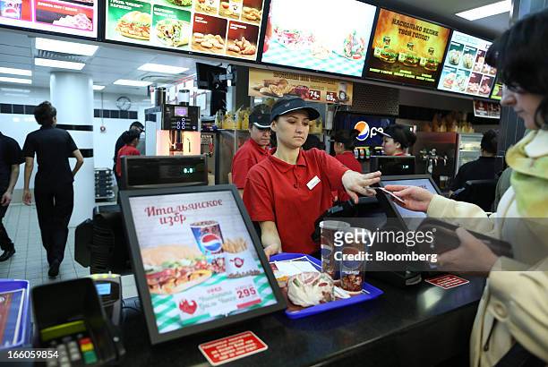 Customer, right, pays an employee for a food order at the service counter of a Burger King fast food restaurant in Moscow, Russia, on Friday, April...