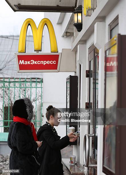 Customers queue to place their orders at a service window outside a McDonald's food restaurant in Moscow, Russia, on Sunday, April 7, 2013....