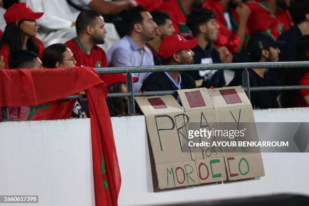 Moroccan fans display a sign that reads "Pray for Morocco" during the International friendly football match between Morocco and Burkina Faso at the...