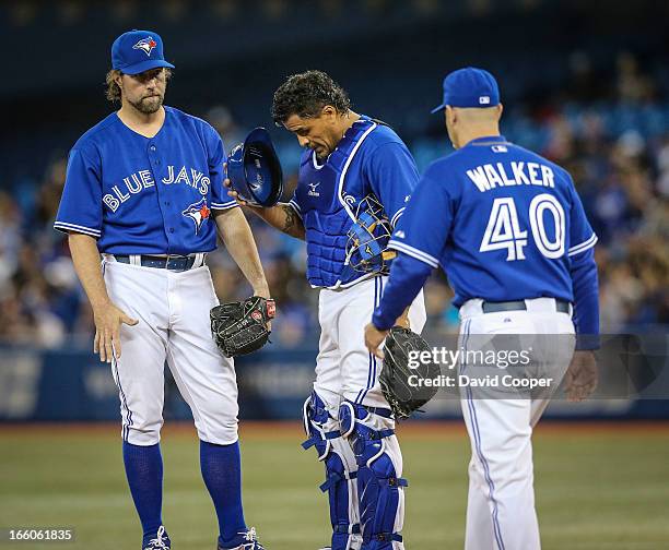 Blue Jays Pitcher R.A. Dickey gets a visit on the mound from his catcher Henry Blanco and pitching coach Pete Walker after a rough start during the...