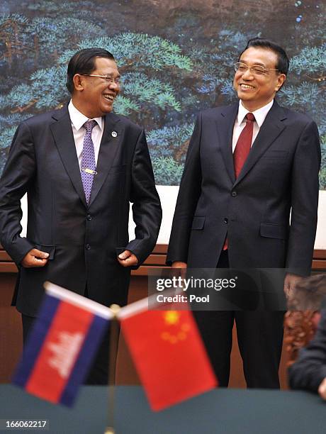 Cambodian Prime Minister Hun Sen and Chinese Premier Li Keqiang smile during a signing ceremony at Great Hall of the People in Beijing on April 8,...