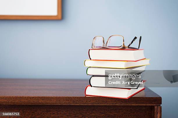 glasses on a stack of books - stack photos et images de collection