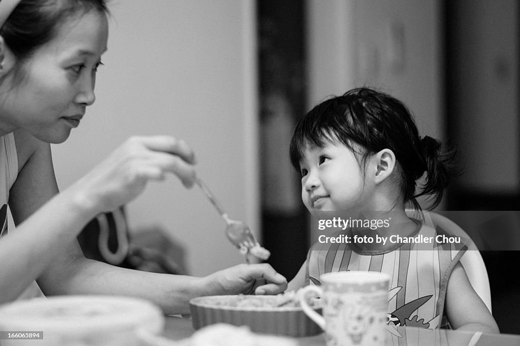 Girl eating dinner with her mom