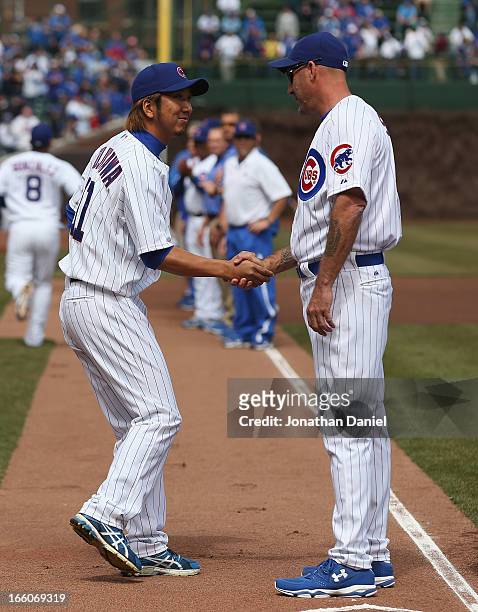 Kyuji Fujikawa of the Chicago Cubs shakes hands with manager Dale Sveum during player introductions before the Opening Day game against the Milwaukee...