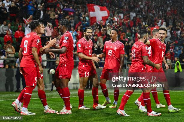 Switzerland's midfielder Granit Xhaka celebrates with teammates after he scored the second goal of his team during the UEFA Euro 2024 football...