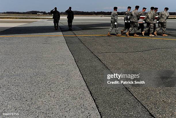 Army soldiers carry the flag-draped transfer case containing the remains of Department of Defense Civilian Hyun K. Shin during a dignified transfer...