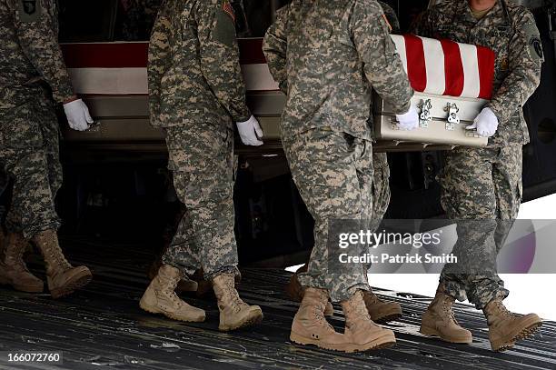Army soldiers carry the flag-draped transfer case containing the remains of U.S. Army Staff Sgt., Christopher M. Ward during a dignified transfer at...