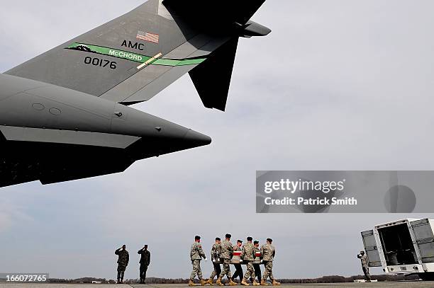 Army soldiers carry the flag-draped transfer case containing the remains of Department of Defense Civilian Hyun K. Shin during a dignified transfer...