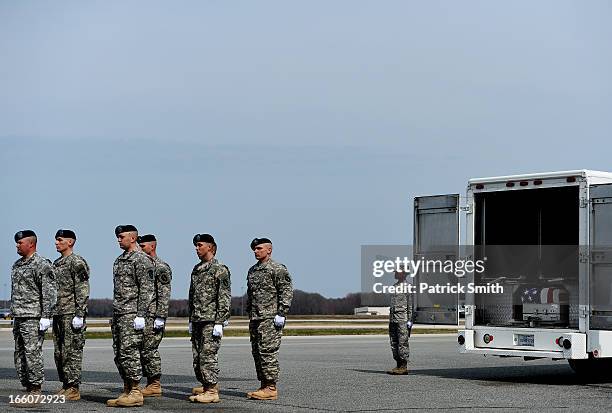 Army soldiers walk away from the transfer vehicle after they placed the flag-draped transfer cases containing the remains of Department of Defense...