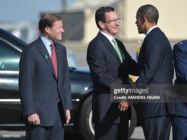 President Barack Obama shakes hands with Connecticut Governor Dannel Malloy as Senator Richard Blumenthal watches upon Obama's arrival at Bradley Air...