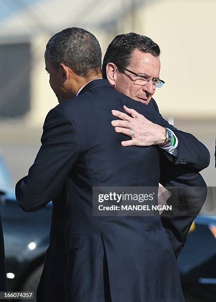 President Barack Obama hugs Connecticut Governor Dannel Malloy upon his arrival at Bradley Air National Guard Base in Hartford, Connecticut, on April...