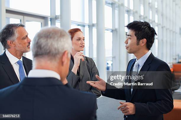 business people talking in office lobby - 全套西裝 個照片及圖片檔