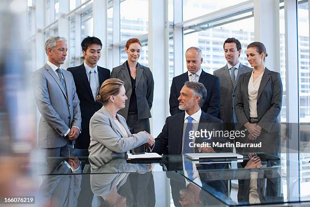 business people shaking hands in conference room - merger stock pictures, royalty-free photos & images